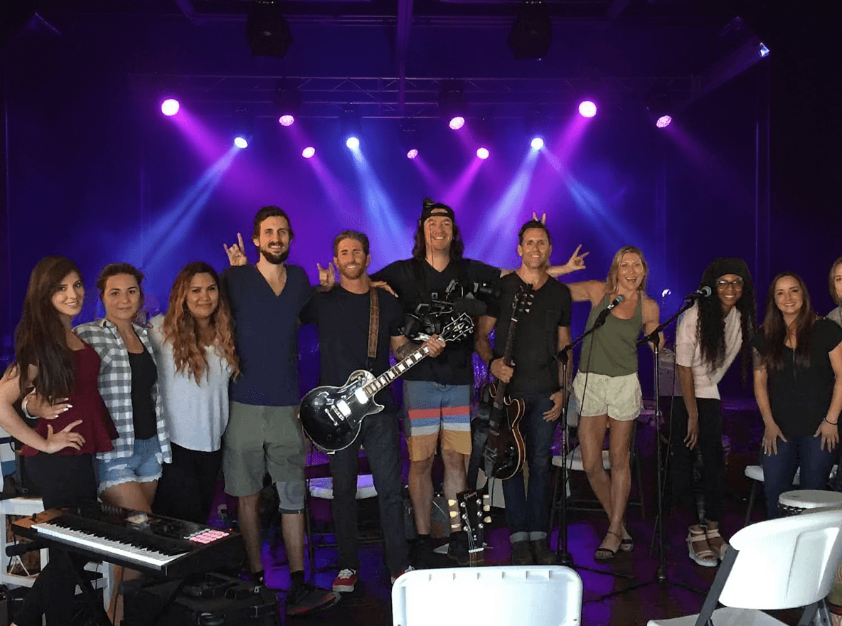 Group music therapy class on stage with purple lighting